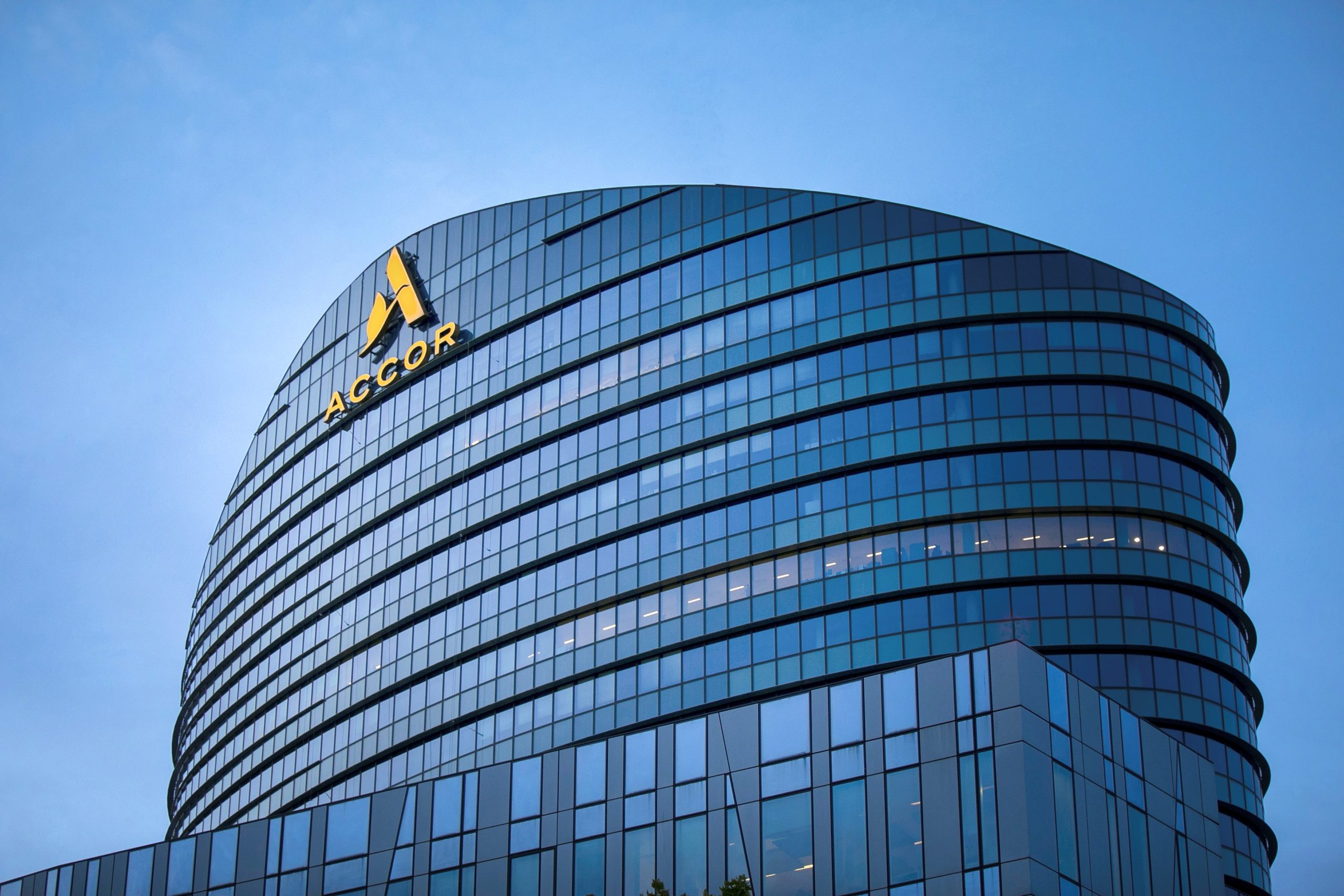 Accor tower with the Accor logo against a blue sky