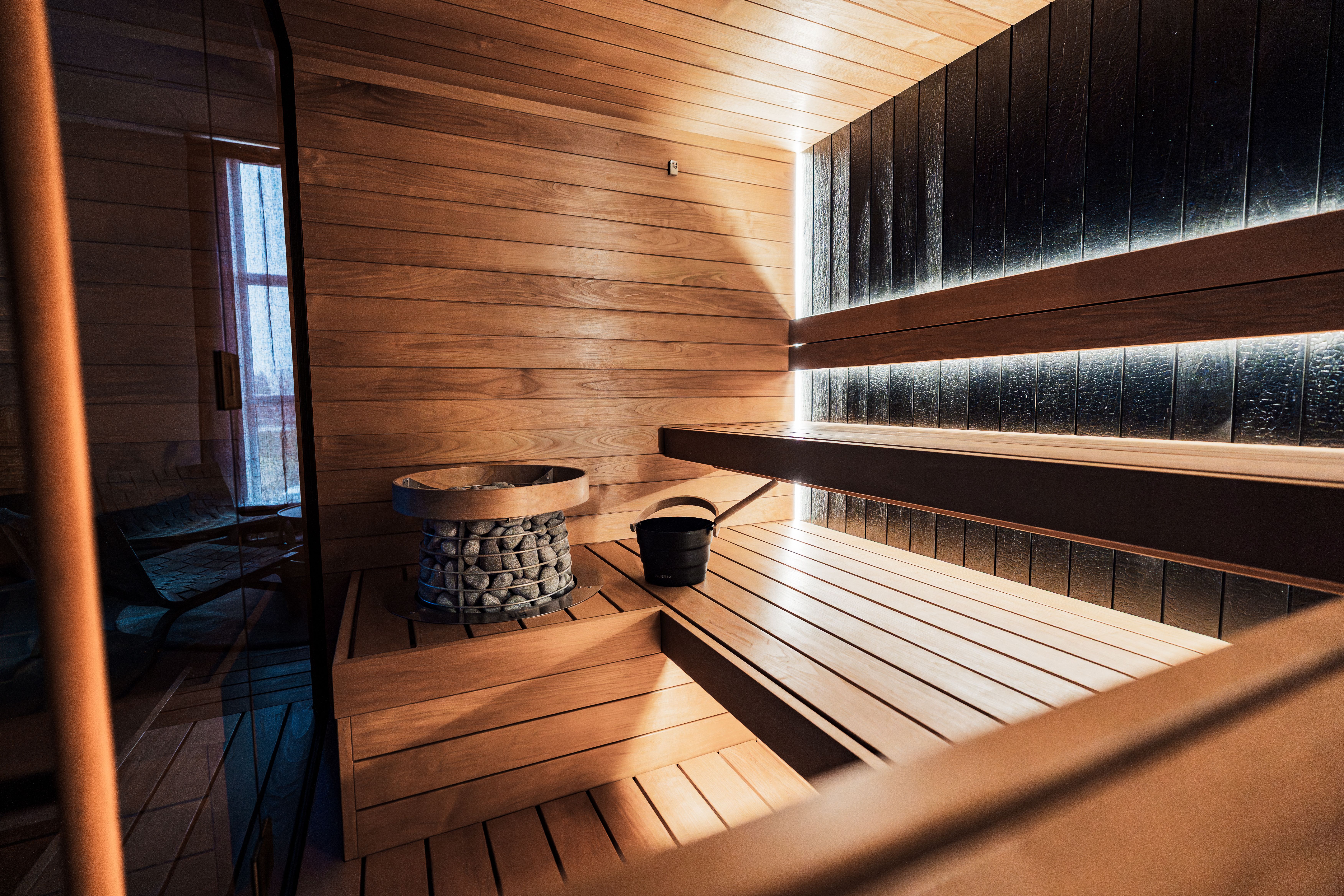 Warm wooden sauna interior with a stone heater at a spa hotel